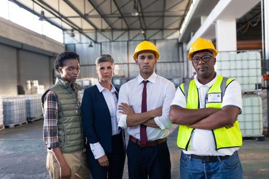 Portrait of diverse male and female staffs standing together in warehouse. This is a freight transportation and distribution warehouse. Industrial and industrial workers concept