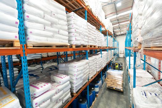 High angle view of African-american male worker driving forklift in warehouse. This is a freight transportation and distribution warehouse. Industrial and industrial workers concept