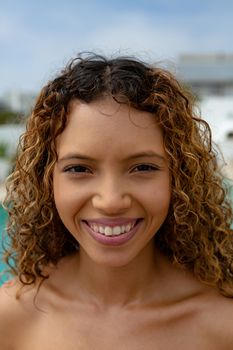 Portrait close-up of happy mixed-race woman looking at camera. Summer fun at home by the swimming pool