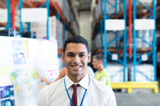 Portrait of happy Caucasian male supervisor looking at camera in warehouse. This is a freight transportation and distribution warehouse. Industrial and industrial workers concept
