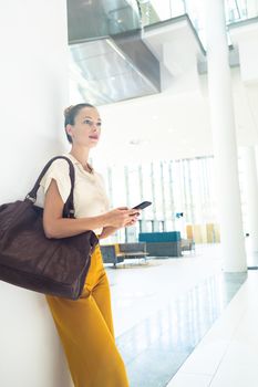 Side view of Caucasian female executive looking away while standing in modern office