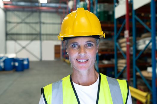 Front view of Happy Caucasian female staff looking at camera in warehous. This is a freight transportation and distribution warehouse. Industrial and industrial workers concept