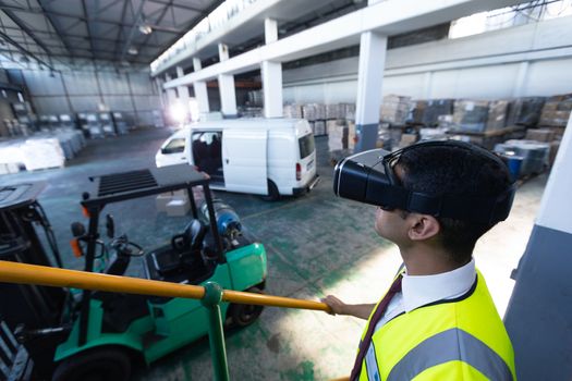 Close-up of Caucasian male supervisor using virtual reality headset in warehouse. This is a freight transportation and distribution warehouse. Industrial and industrial workers concept