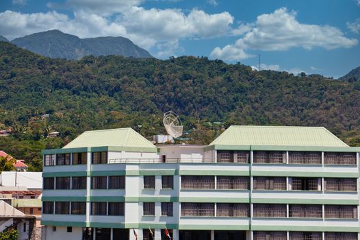 A small tropical hotel with a satellite dish on the roof