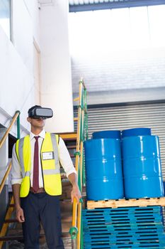 Front view of young Caucasian male supervisor using virtual reality headset in warehouse. This is a freight transportation and distribution warehouse. Industrial and industrial workers concept