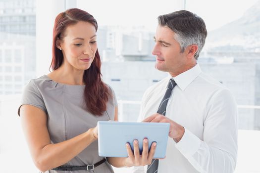 Business people holding a tablet and checking notes