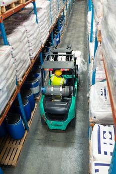 High angle rear view of African-american male worker driving forklift in warehouse. This is a freight transportation and distribution warehouse. Industrial and industrial workers concept