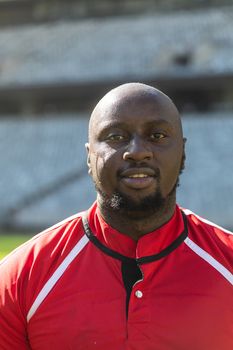 Portrait close up of handsome African American rugby player looking at camera in the stadium on sunny day.