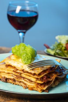 portion of fresh lasagna on a blue plate