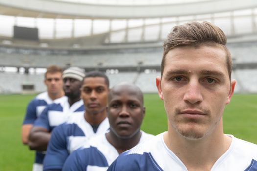 Portrait of diverse male rugby players standing together in stadium