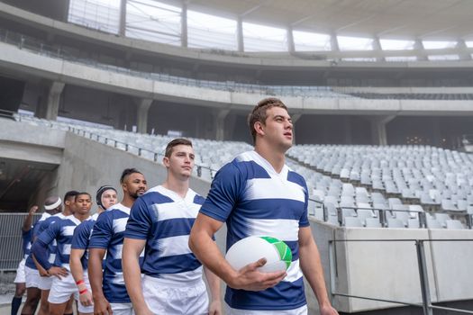 Side View of group of diverse rugby players entering stadium in a row for match