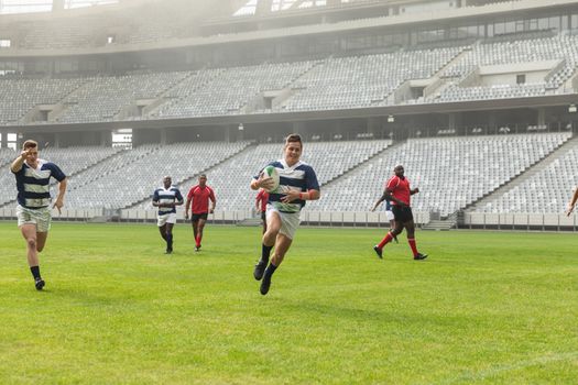  Front view of group of diverse male rugby players playing rugby in stadium