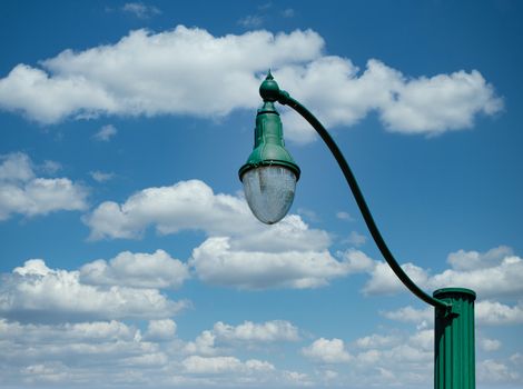 An old fashioned green lamp post against the sky