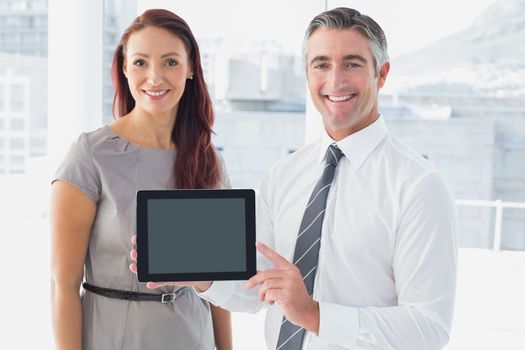 Business people holding up tablet to the camera