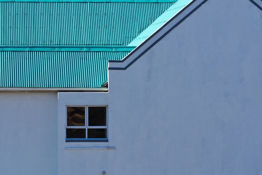 Building wall and roof close-up feature with a window, Mossel Bay, South Africa