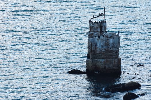 A weathered landmark beacon on a rocky coastal outcrop, Cape Town, South Africa