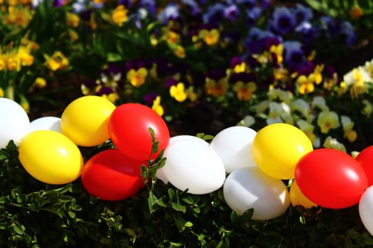 The picture shows happy easter greetings with eastereggs and flowers