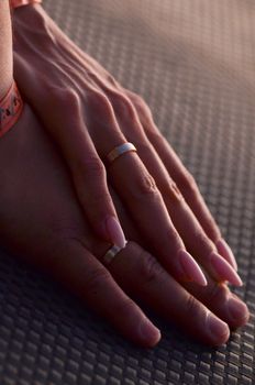 Newlyweds hands with wedding rings on the finger clasped together