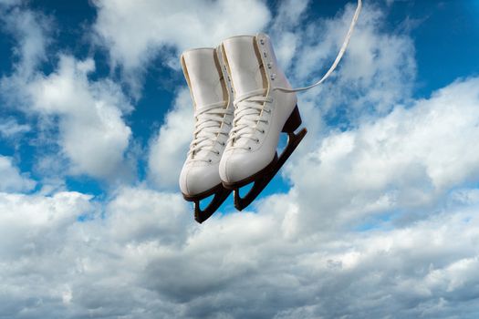 Collage, A pair of figure skates against a blue sky with white clouds