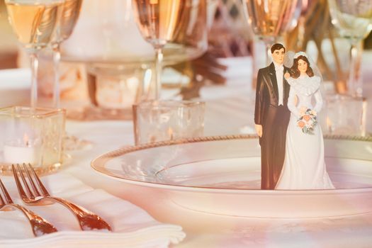 Cake figurines resting on plate at reception