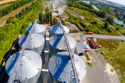 Flight of the grain terminal from the drone. The grain plant for storage and drying of grain. Grain terminal. Plant for the drying and storage Rice plant in the middle of fields.