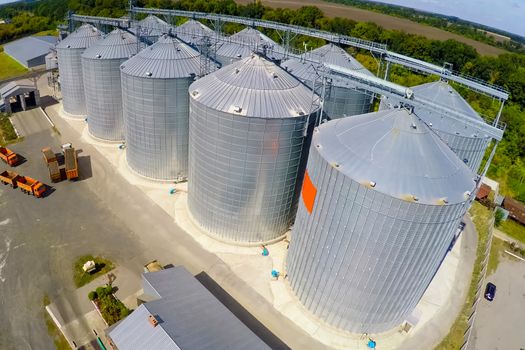 Flight of the grain terminal from the drone. The grain plant for storage and drying of grain. Grain terminal. Plant for the drying and storage Rice plant in the middle of fields.