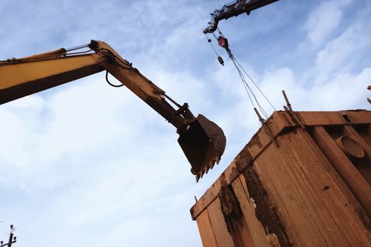 Bulldozer bucket above the container. The bulldozer is digging.