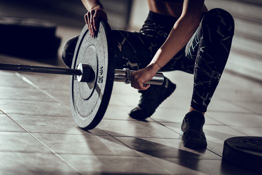 Close-up of a fit woman's hands getting ready to weightlifting at the garage gym.