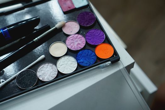 Use palette of shadows for makeup on a blurred background, closeup