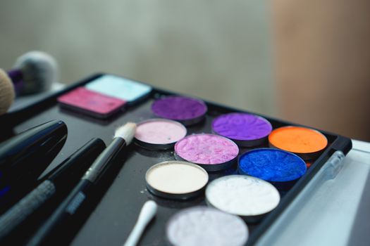 Use palette of shadows for makeup on a blurred background, closeup