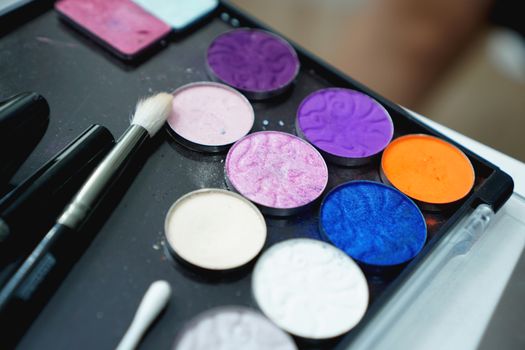 Use palette of shadows for makeup on a blurred background, closeup