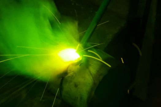 Metal pipe during welding. Sparks and scale.