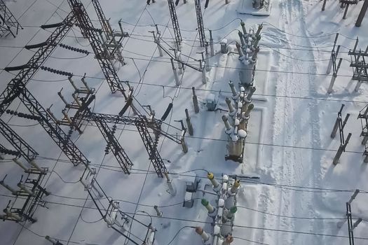 Electrical substation in the snow in winter. High voltage wires