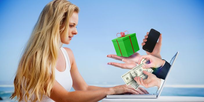 Composite image of pretty blonde using her laptop at the beach with hands