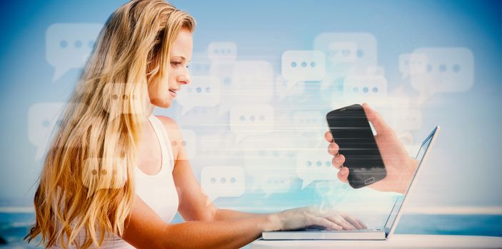 Composite image of pretty blonde using her laptop at the beach with hand holding phone