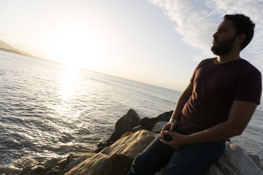 Man sitting on the rocks enjoying the sea view