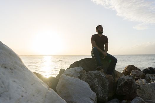 Man sitting on the rocks enjoying the sea view