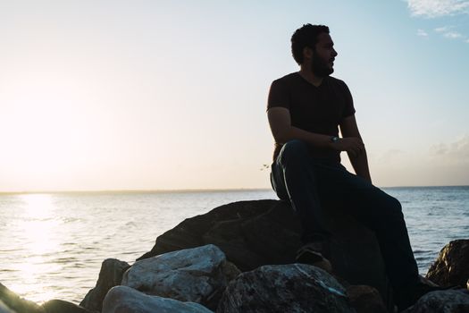 Man sitting on the rocks enjoying the sea view