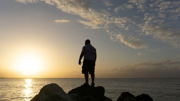 Man standing on the rocks enjoying the ocean view