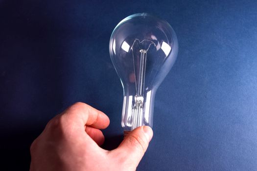 Incandescent lamp in the hand. Lamp is the source of lighting.