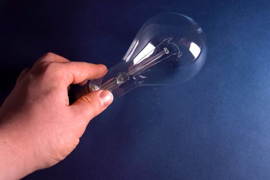 Incandescent lamp in the hand. Lamp is the source of lighting.