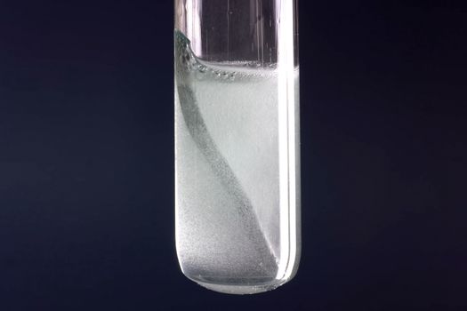 Laboratory flask with a tungsten plate in alkali.