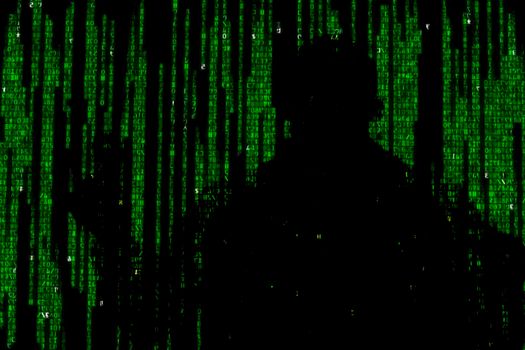 Silhouette of man in green digital data. The symbol of a hacker