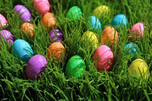 The picture shows colourful eastereggs in eastergrass