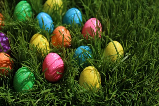 The picture shows colourful eastereggs in eastergrass