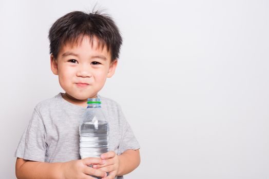 Closeup Asian face, Little children boy drinking water from Plastic bottle on white background with copy space, health medical care