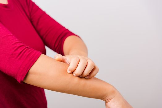 Asian beautiful woman itching her scratching her itchy arm on white background with copy space, Medical and Healthcare concept