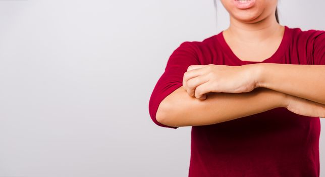 Asian beautiful woman itching her scratching her itchy arm on white background with copy space, Medical and Healthcare concept