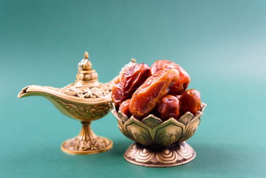 Ramadan, Dates in golden bowl, arabian Aladdin golden lamp vintage style on black green background