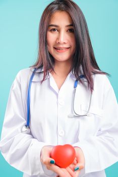 Portrait asian beautiful doctor woman smiling her standing with stethoscope holding heart on blue background, with copy space for text
